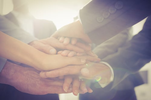 Business team standing hands together in the office Business team standing hands together in the office