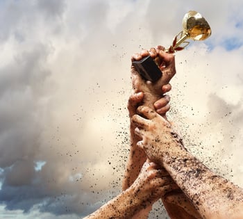 Hands squeeze the cup winner against lightning dark sky. Hands squeeze the cup winner against lightning dark sky.